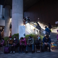 Members of the public wait in line outside a COVID-19 community testing center in Hong Kong on Thursday.  | BLOOMBERG 