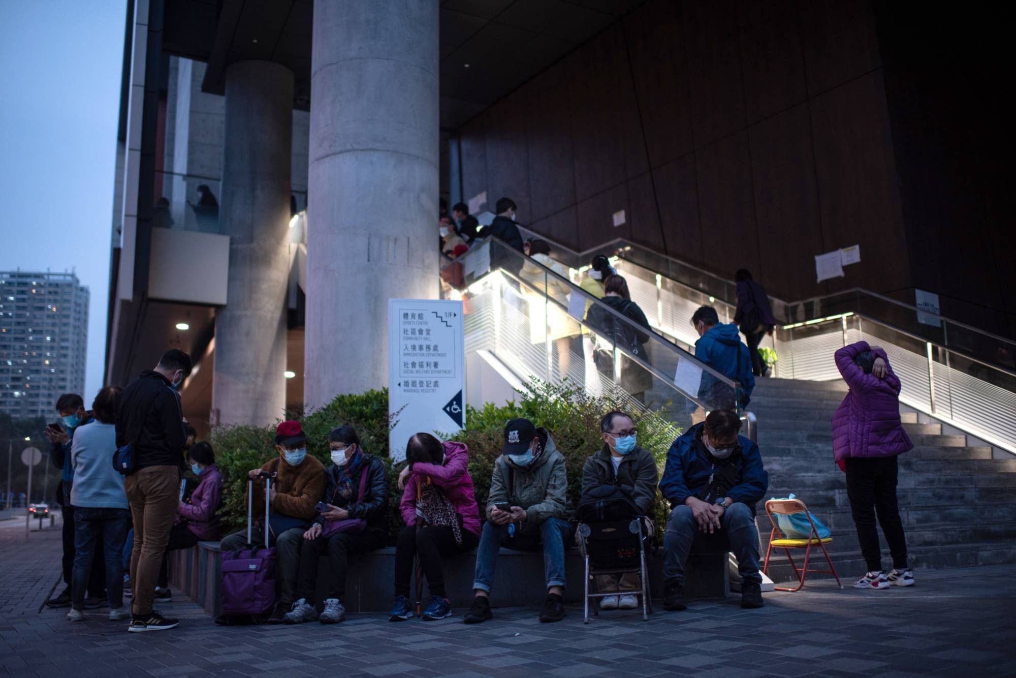 Members of the public wait in line outside a COVID-19 community testing center in Hong Kong on Thursday. | Bloomberg 