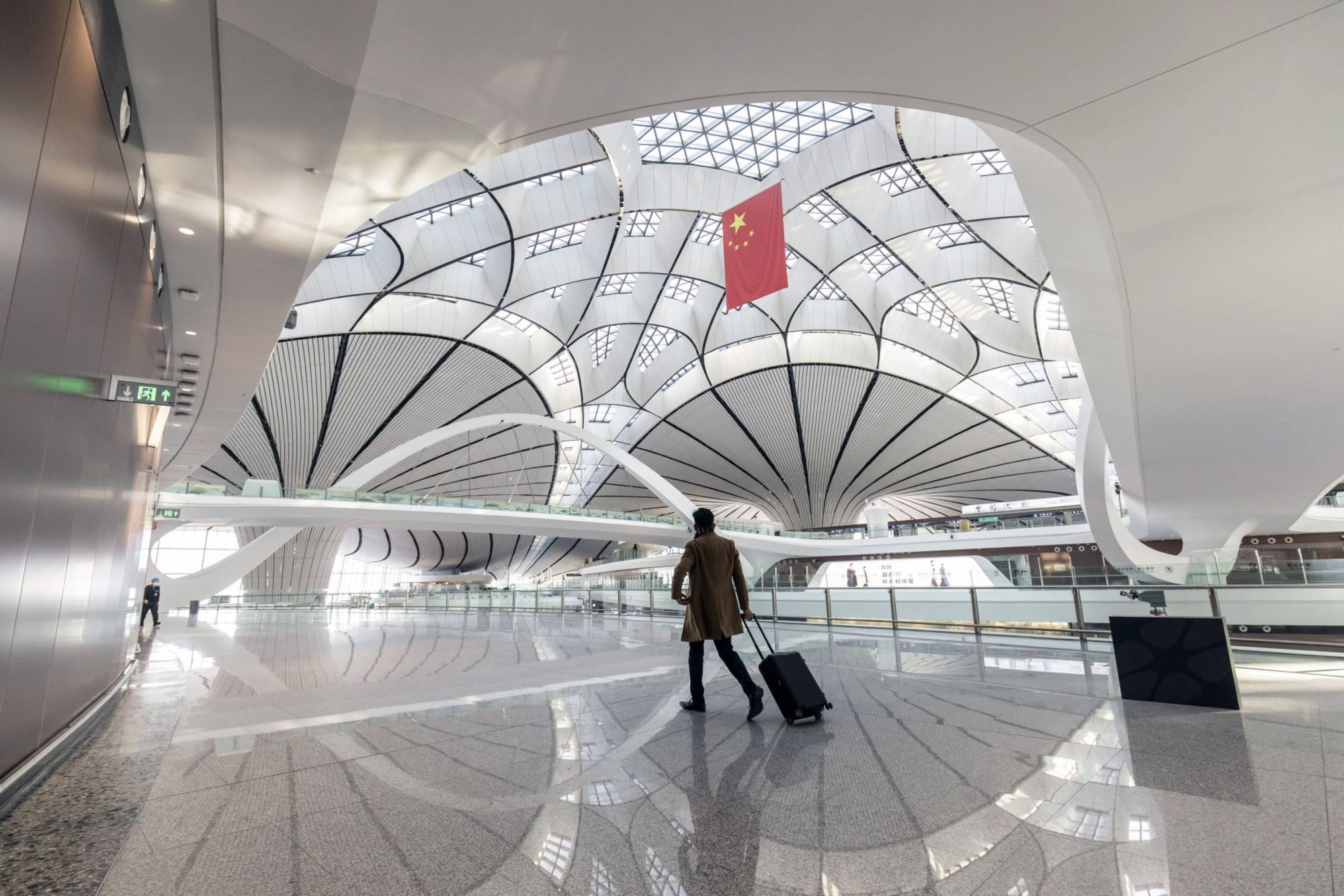 A traveler walks through Beijing Daxing International Airport in November. | BLOOMBERG 