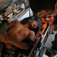 Liu Zi-Xian, 25, has his blood pressure measured in an ambulance after falling ill during the last week of training. The trainees have to endure everything from long marches to hours in the water, with constant screaming at by their instructors. Of the group of 31 who started the program, only 15 finished. | REUTERS
