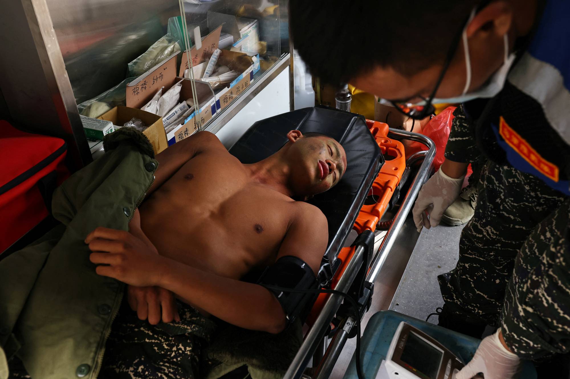 Liu Zi-Xian, 25, has his blood pressure measured in an ambulance after falling ill during the last week of training. The trainees have to endure everything from long marches to hours in the water, with constant screaming at by their instructors. Of the group of 31 who started the program, only 15 finished. | Reuters