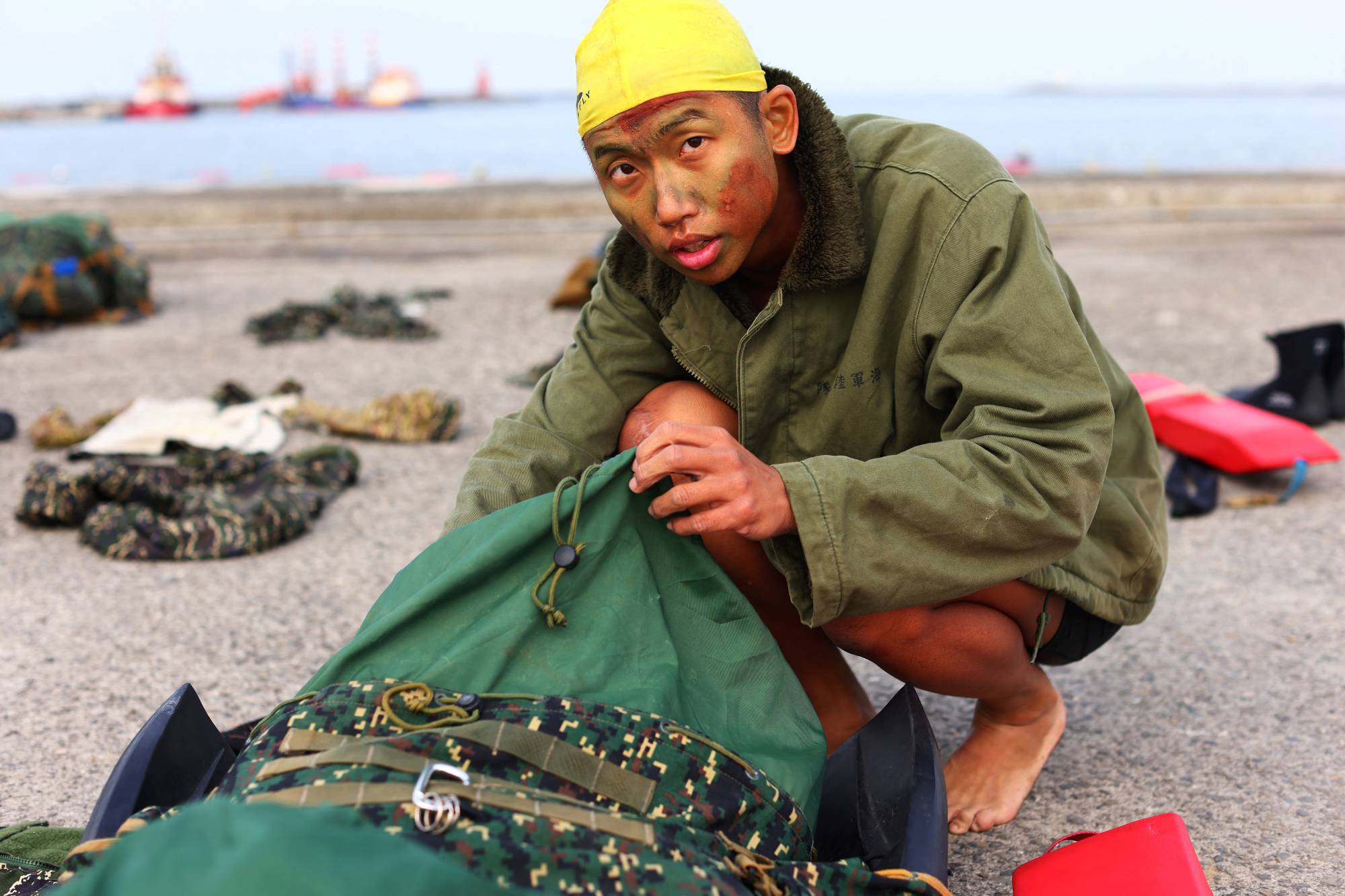 Liu Zi-Xian, 25, prepares to change into running clothes after a long swim as part of training for Taiwan's elite Amphibious Reconnaissance and Patrol unit. | Reuters