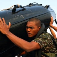 Ou Zhi-Xuan, 25, helps to carry a rubber boat out of the sea during training on Dec. 17.  | REUTERS 