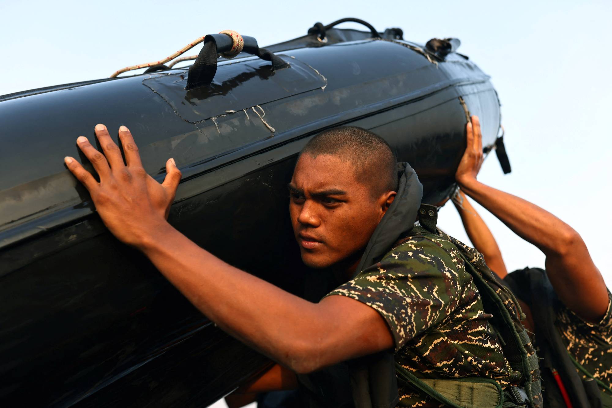 Ou Zhi-Xuan, 25, helps to carry a rubber boat out of the sea during training on Dec. 17. | Reuters 