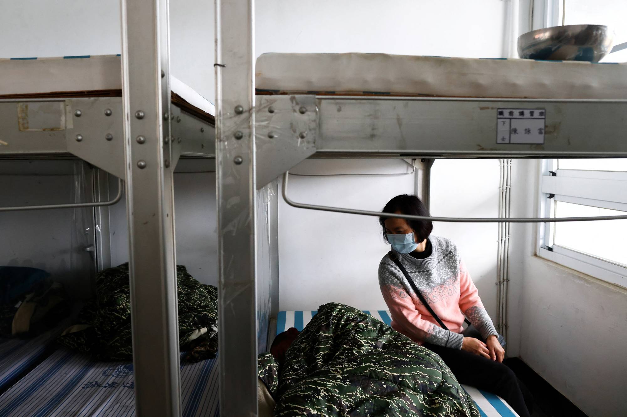 Liu Zi-Xian is comforted by his mother while resting in his bunk, at Zuoying navy base in Kaohsiung, Taiwan. | Reuters