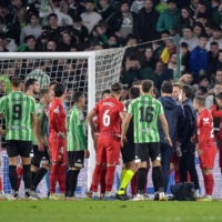 Sevilla midfielder receives assistance after being hit by an object thrown from the stands during a Spanish Cup round-of-16 game between Sevilla and Real Betis in Seville on Saturday. | AFP-JIJI