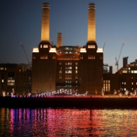 The River Thames is illuminated by a light installation called \'Eternal Sundown\' by Mads Vegas, part of The Lights Festival at Battersea Power Station in London on Sunday. | REUTERS