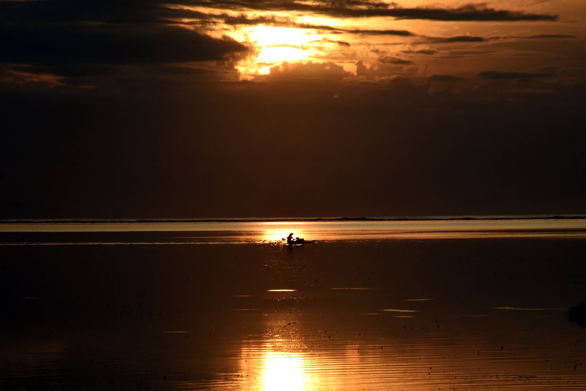 A fisherman paddles his boat during sunrise by a beach in Sanur on the Indonesian island of Bali on January 16.  | AFP-JIJI