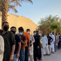 Unemployed men queue for food handouts from concerned local residents after they lost income due to the COVID-19 pandemic, in Dubai in July 2020. | REUTERS