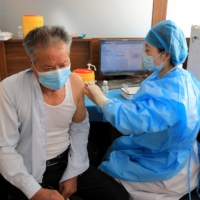 A resident receives a booster shot of the Sinovac COVID-19 vaccine in Rongcheng, in China\'s eastern Shandong province, on Jan. 9. | AFP-JIJI
