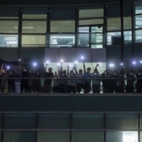 Workers illuminate mobile phone torches from a balcony at the headquarters of the Apple Daily newspaper and its publisher Next Digital Ltd. in Hong Kong, China, on Wednesday, June 23, 2021. | BLOOMBERG