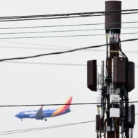 A Southwest Airlines Co. Boeing 737 airplane passes a 5G cellular tower as it lands at Los Angeles International Airport in the Lennox neighborhood of Los Angeles, California, on Wednesday. Telecom giants AT&T and Verizon began 5G cell phone data service in the United States the same day without major disruptions to flights after the launch of the new wireless technology was scaled back. | AFP-JIJI