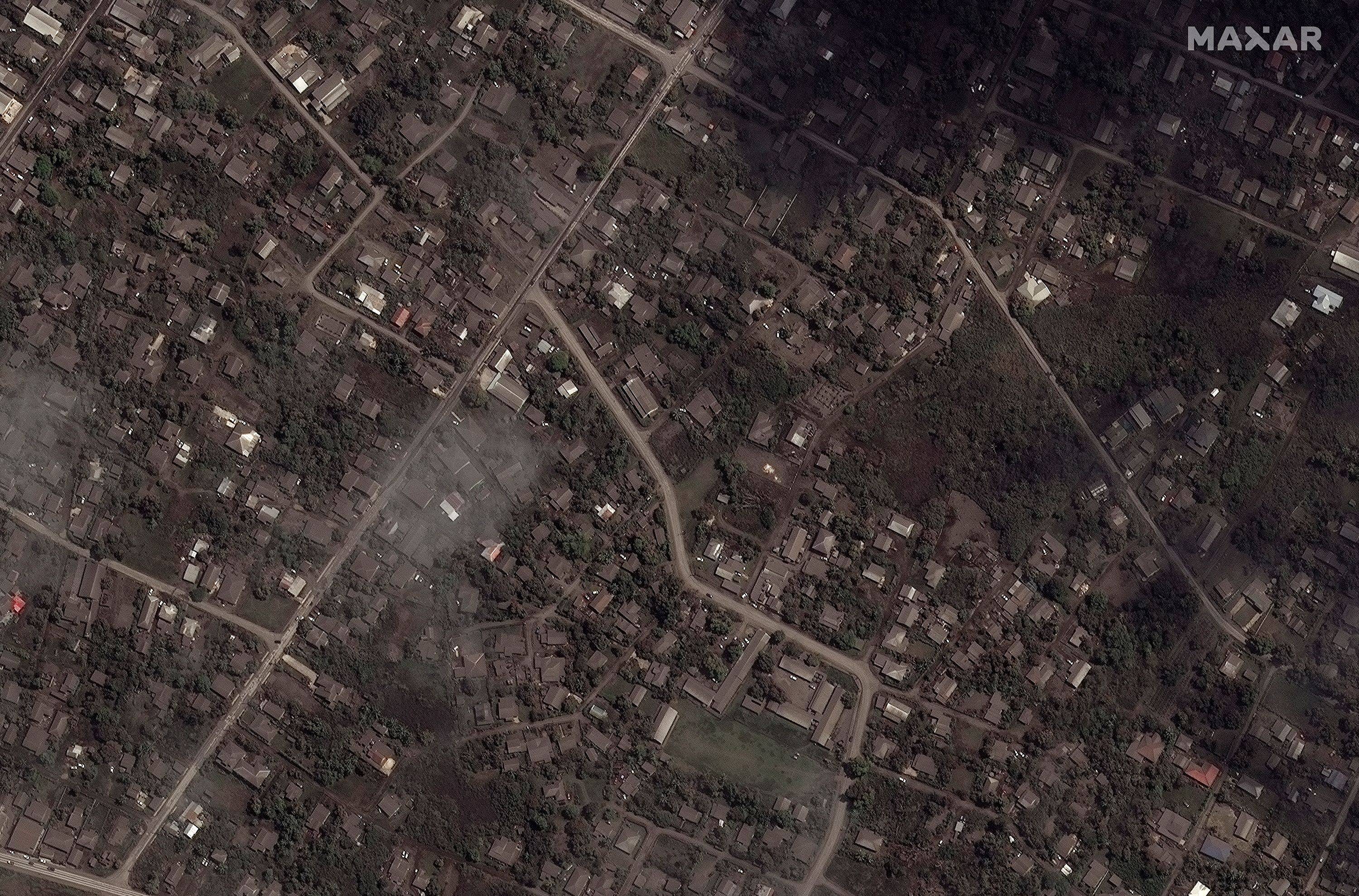 A satellite image shows ash covered homes and buildings after the main eruption of the Hunga Tonga-Hunga Ha'apai volcano, in Nuku'alofa, Tonga, on Tuesday. | MAXAR TECHNOLOGIES / VIA REUTERS