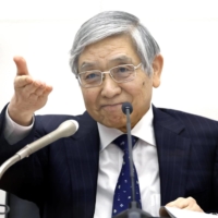 Bank of Japan Gov. Haruhiko Kuroda gestures during a news conference in Tokyo on Tuesday.  | BLOOMBERG 