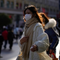 A woman walks along a street in Shanghai on Thursday.  | REUTERS