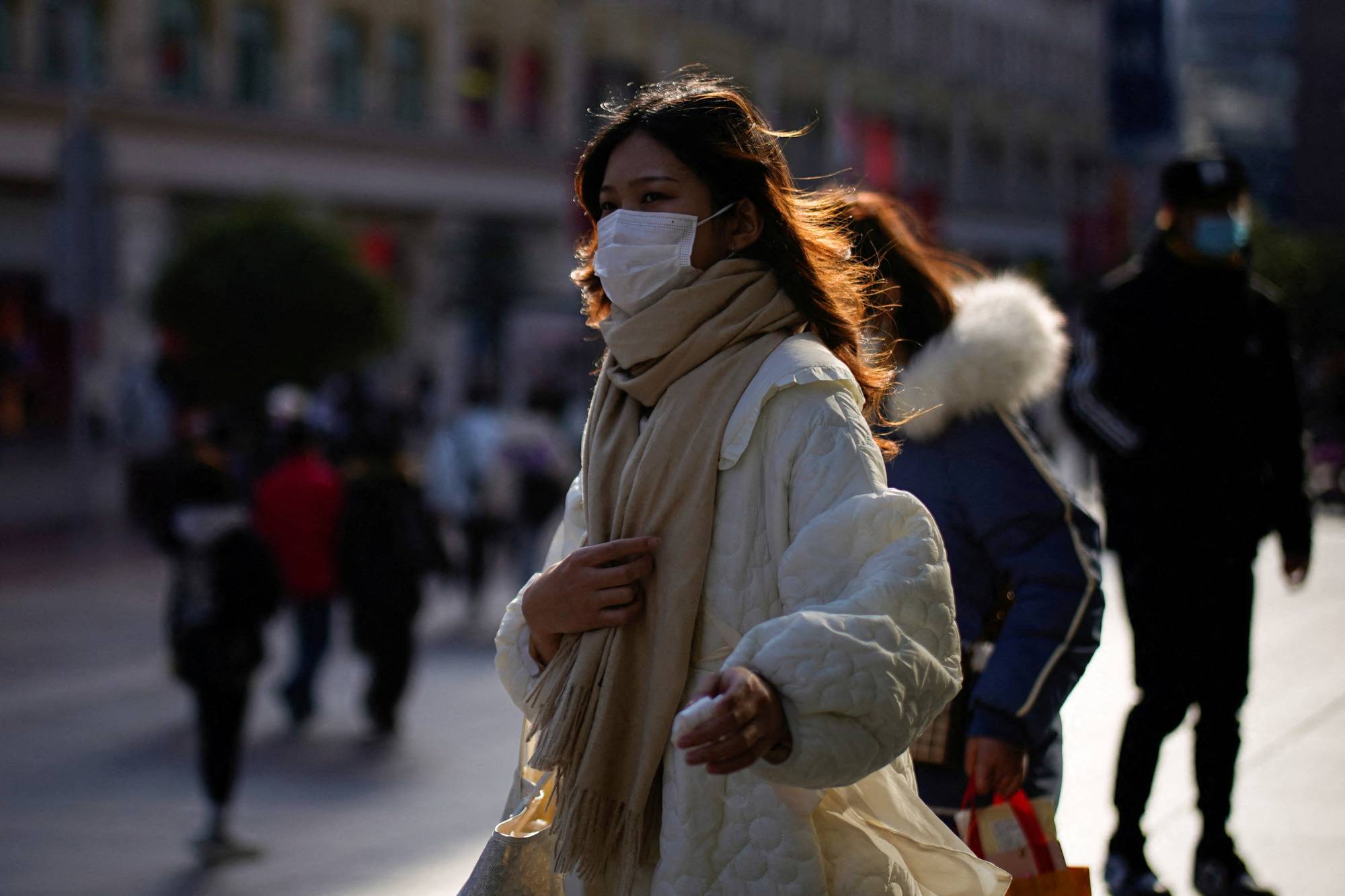 A woman walks along a street in Shanghai on Thursday. | Reuters