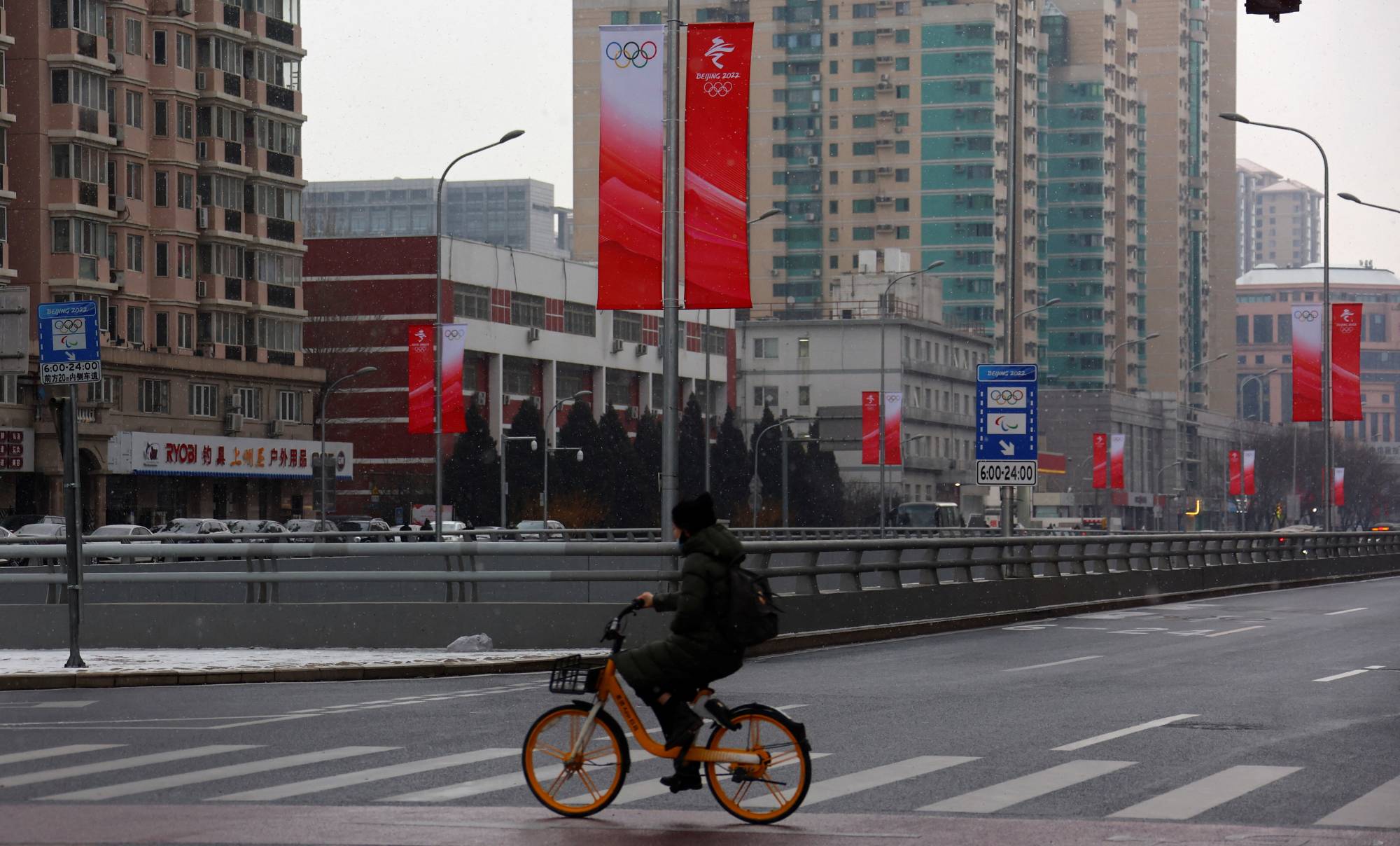A man rides his bicycle outside the closed loop area designed to prevent the spread of the coronavirus near Olympic venues in Beijing on Thursday. | Reuters