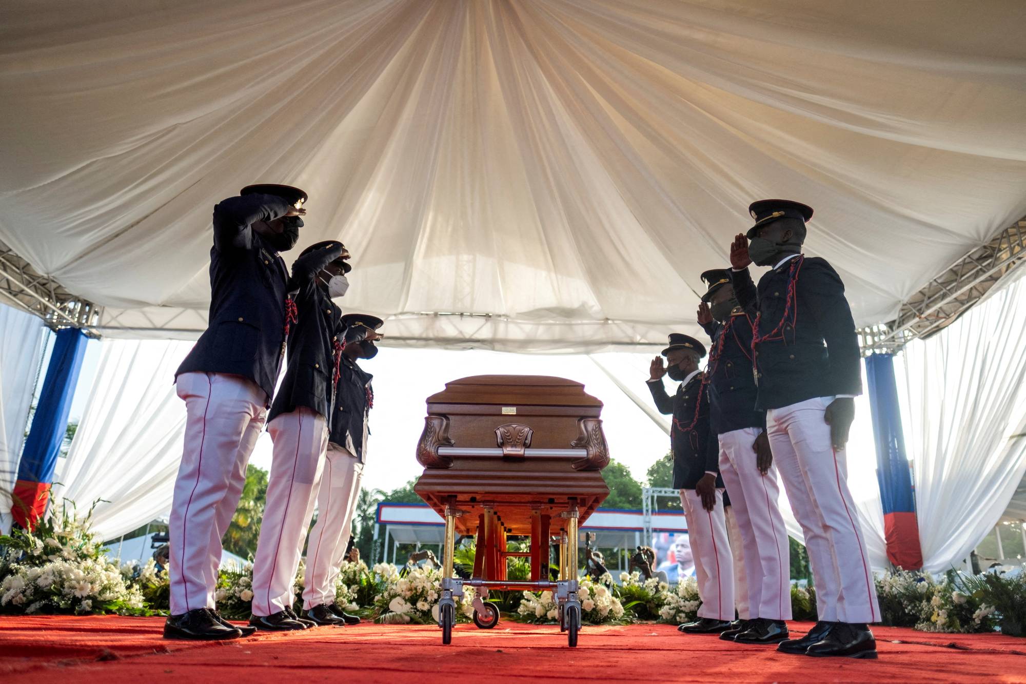 A presidential honor guard salutes next to the coffin of late Haitian President Jovenel Moise at his funeral on July 23. | REUTERS