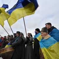 People form a symbolic human chain on a bridge across the Dnieper river in Kyiv to mark the Day of Unity of Ukraine, on Jan. 22. Ukraine marks the 103rd anniversary of the unification of eastern and western Ukraine in 1919. | AFP-JIJI