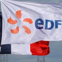 The logo of Electricite de France (EDF) flies next to the French flag fly near an EDF power plant in Bouchain, France, on Sep. 29. | REUTERS