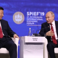 Russian President Vladimir Putin sits beside Chinese leader Xi Jinping during the St. Petersburg International Economic Forum in the Russian city in June 2019. | BLOOMBERG