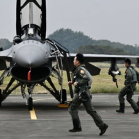 Taiwanese Air Force pilots run past an F-16V fighter jet at an air force base in Chiayi, southern Taiwan, on Jan. 5. | AFP-JIJI