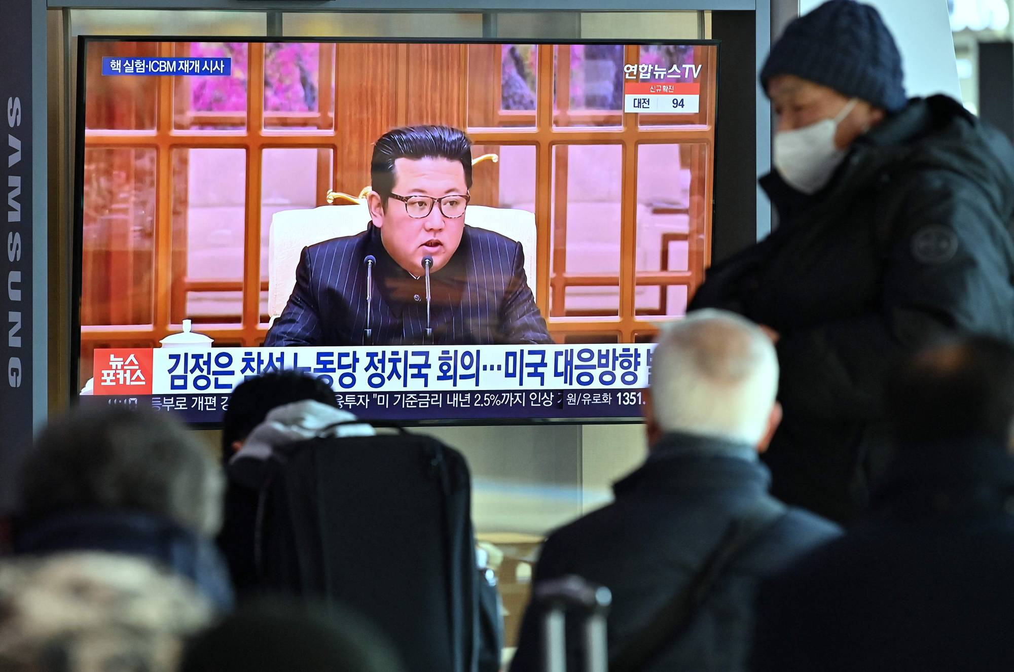 People watch a news broadcast with footage of North Korean leader Kim Jong Un, at a railway station in Seoul on Thursday, after North Korea hinted at resuming weapons tests as it prepared for 