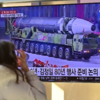 A woman watches footage of a North Korean missile following a string of sanction-busting missile launches this month.  | AFP-JIJI