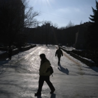 Pedestrians walk in Svitlodarsk, near the front lines in eastern Ukraine, on Saturday. Ukraine estimates that Russia has about 127,000 troops near its borders.  | TYLER HICKS/THE NEW YORK TIMES
