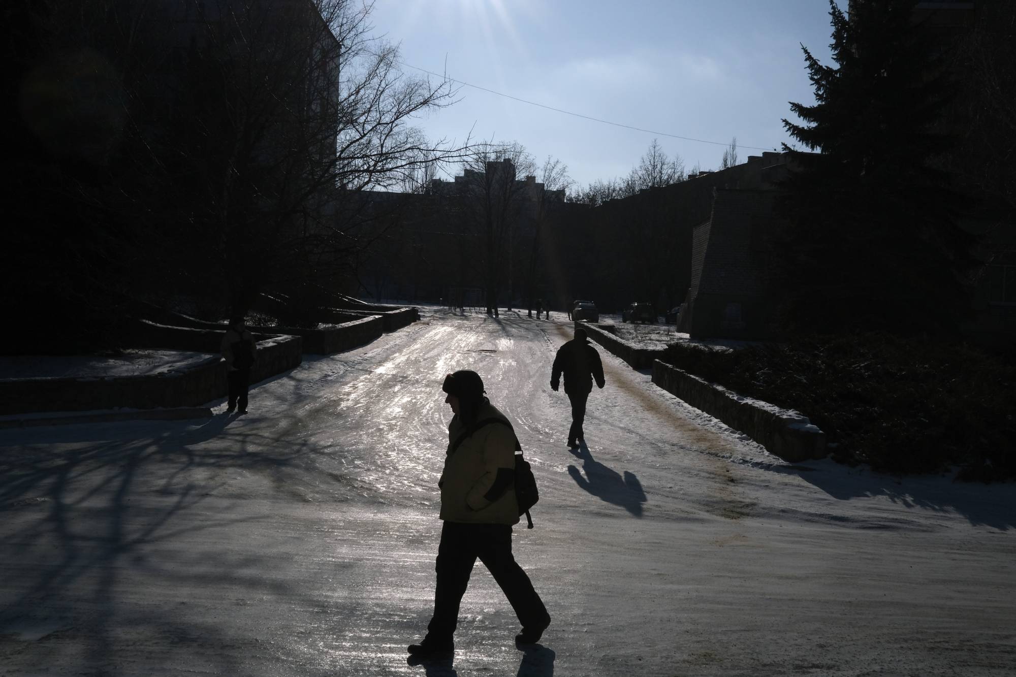 Pedestrians walk in Svitlodarsk, near the front lines in eastern Ukraine, on Saturday. Ukraine estimates that Russia has about 127,000 troops near its borders. | Tyler Hicks/The New York Times