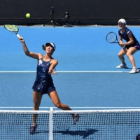 Japan\'s Ena Shibahara (left) hits a return as she plays with partner Shuko Aoyama against Australia\'s Priscilla Hon and Australia\'s Lizette Cabrera during their women\'s doubles match at the Australian Open in Melbourne on Friday. | AFP-JIJI