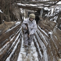 A Ukrainian soldier walks in a trench on the border with Russia, near Katerynivka, Ukraine, on Jan. 18. | TYLER HICKS / THE NEW YORK TIMES