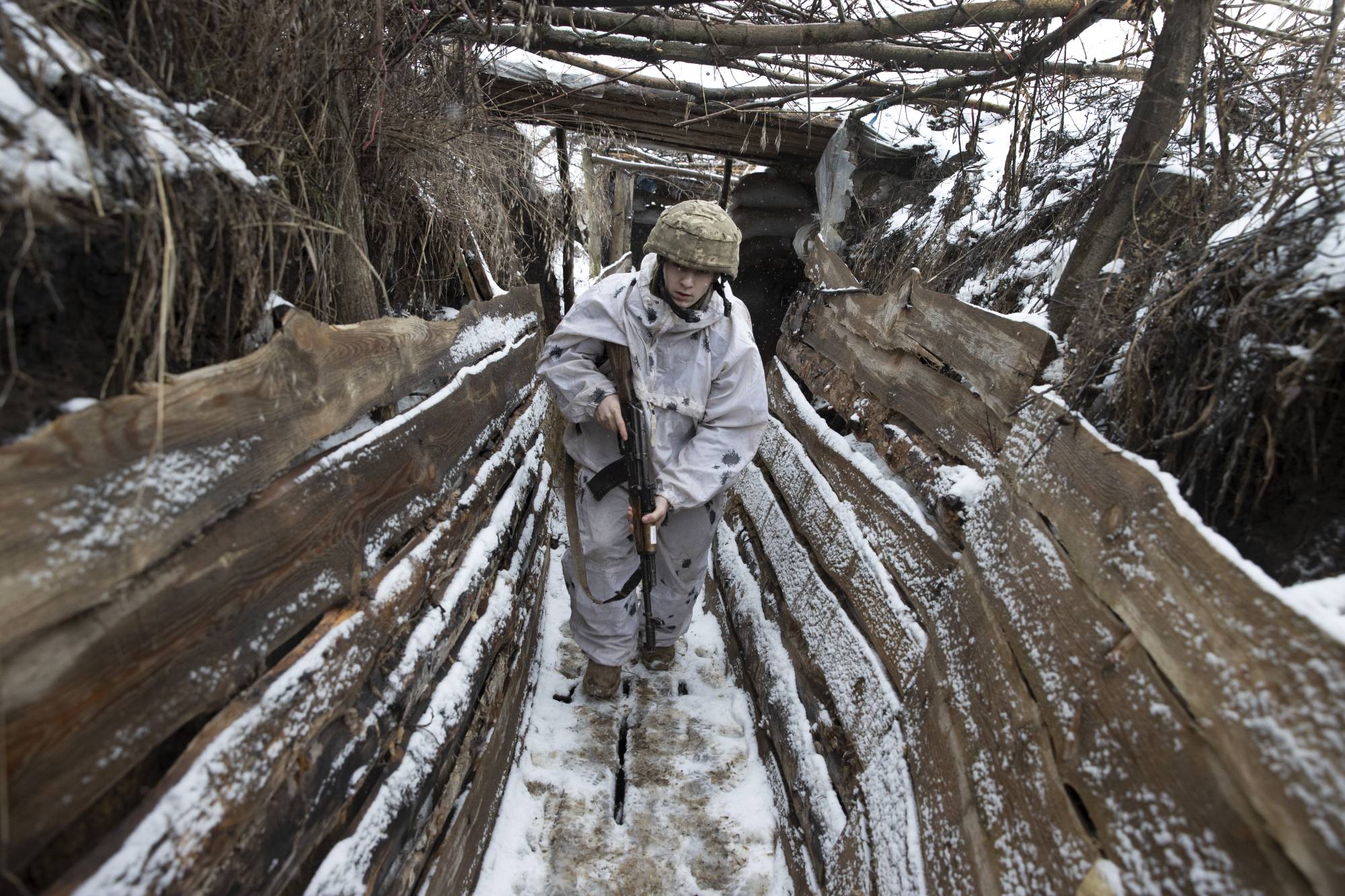A Ukrainian soldier walks in a trench on the border with Russia, near Katerynivka, Ukraine, on Jan. 18. | Tyler Hicks / The New York Times