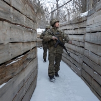 Ukrainian soldiers walk in a trench in the front line city of Marinka, Ukraine, on Thursday.  | TYLER HICKS / THE NEW YORK TIMES