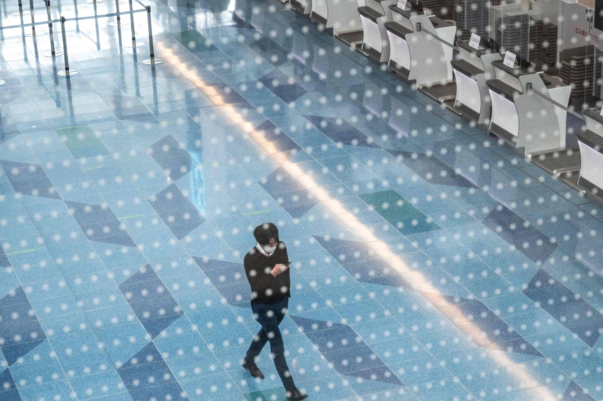 A man walks in an empty departures hall at Tokyo's Haneda Airport on Tuesday. | AFP-JIJI