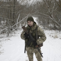 A Ukrainian border guard patrols inside the Chernobyl Exclusion Zone, near the Ukraine-Belarus border, on Jan. 9. From the border, it\'s a fast 140 miles down a newly paved highway to Kyiv, the Ukrainian capital, but only a few troops stand guard.  | BRENDAN HOFFMAN/THE NEW YORK TIMES
