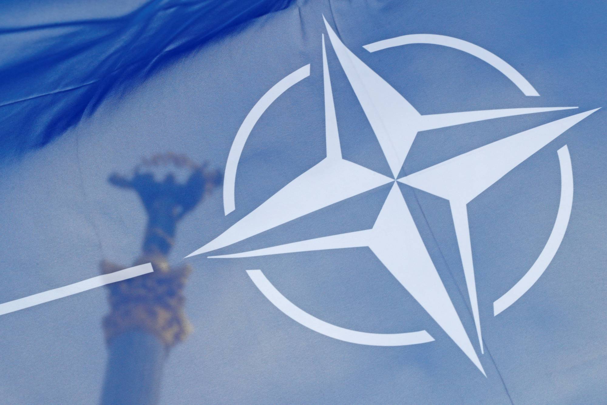 The NATO flag flies in front of the Independence Monument in Kyiv on Sunday. | REUTERS
