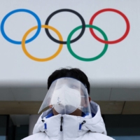 Photo: A volunteer wearing a face mask and shield is seen at the National Aquatics Center in Beijing on Sunday.  | REUTERS