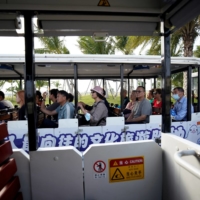 Visitors ride a shuttle bus on the man-made Ocean Flower Island, a resort developed by China Evergrande Group, in Danzhou, Hainan province, China, on Jan. 7. | REUTERS