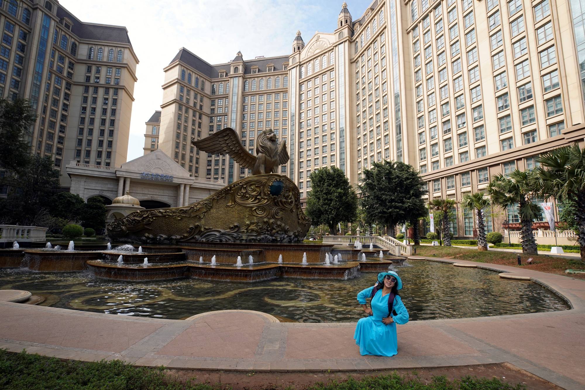 A visitor poses for pictures at Castle Hotel on the man-made Ocean Flower Island, a resort developed by China Evergrande Group, in Danzhou, Hainan province, China, on Jan. 7. | REUTERS