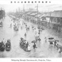 A postcard shows people wading in floodwaters at Honjo Kamezawa-cho in present-day Sumida Ward, Tokyo, during the 1910 Great Kanto Flood. | COURTESY OF THE TOKYO METROPOLITAN CENTRAL LIBRARY
