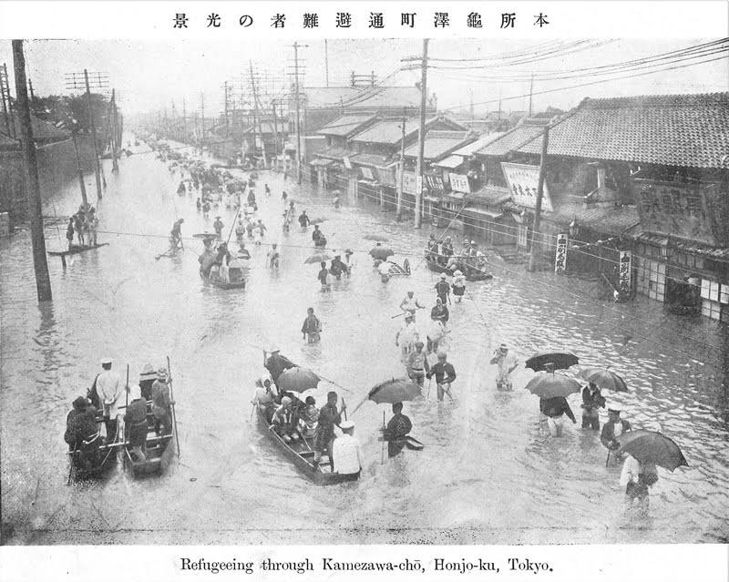 A postcard shows people wading in floodwaters at Honjo Kamezawa-cho in present-day Sumida Ward, Tokyo, during the 1910 Great Kanto Flood. | Courtesy of the Tokyo Metropolitan Central Library