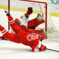 Japan goalie Dusty Imoo makes a sliding save on a shot by Austria\'s Richard Nasheim (front) during an Olympic ice hockey match in Nagano, Japan in February 1998. | REUTERS