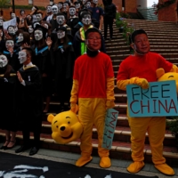 Men wearing Winnie the Pooh costumes and masks depicting Chinese President Xi Jinping at a graduation ceremony to support anti-government protest at the Hong Kong Polytechnic University, in Hong Kong, Oct. 30, 2019. | REUTERS