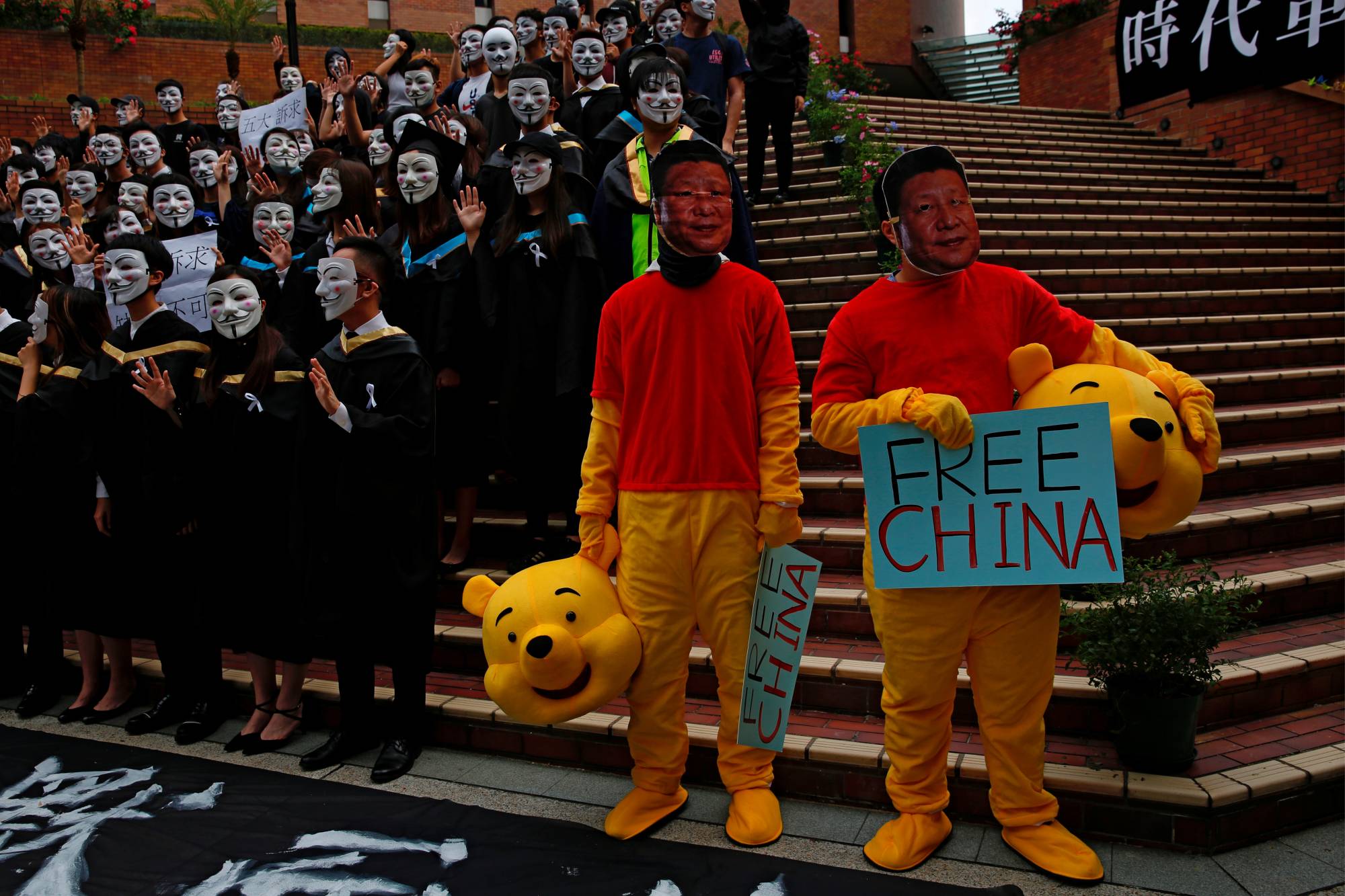 Men wearing Winnie the Pooh costumes and masks depicting Chinese President Xi Jinping at a graduation ceremony to support anti-government protest at the Hong Kong Polytechnic University, in Hong Kong, Oct. 30, 2019. | Reuters