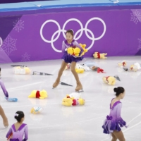 Korean skaters pick up bears thrown onto the ice by fans of Yuzuru Hanyu at the Pyeongchang Winter Olympics on Feb. 16, 2018. | REUTERS