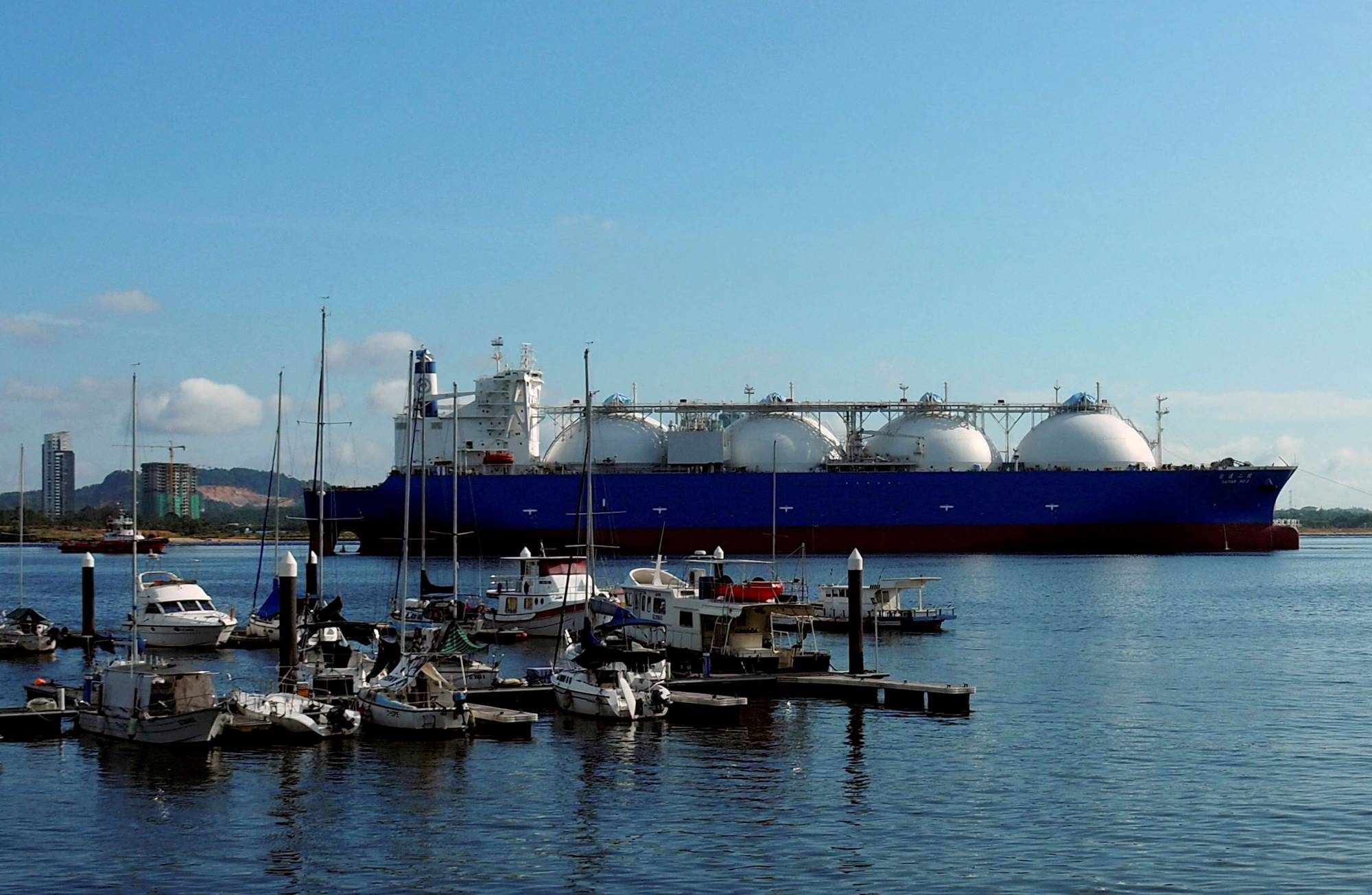 An liquefied natural gas (LNG) tanker passes boats along the coast of Singapore in Feb., 2017.  | REUTERS