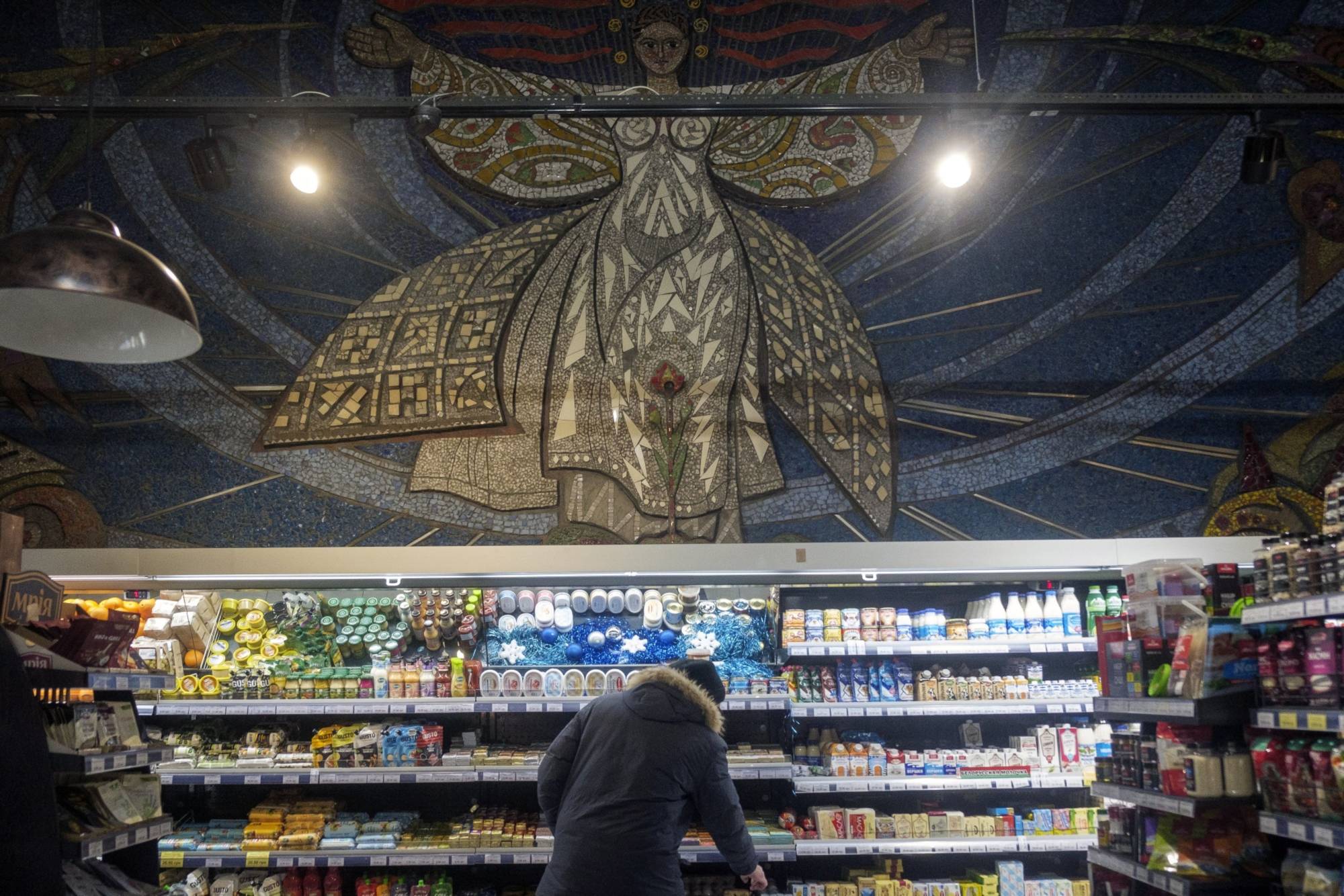 A Soviet-era mosaic above an aisle of a grocery store in Mariupol | Bloomberg 