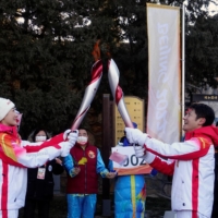 Torchbearers Ding Ning, Chinese table tennis player, and Sa Beining, Chinese state television host, relay the Olympic flame at the Summer Palace in the Haidian district of Beijing on Friday. | REUTERS