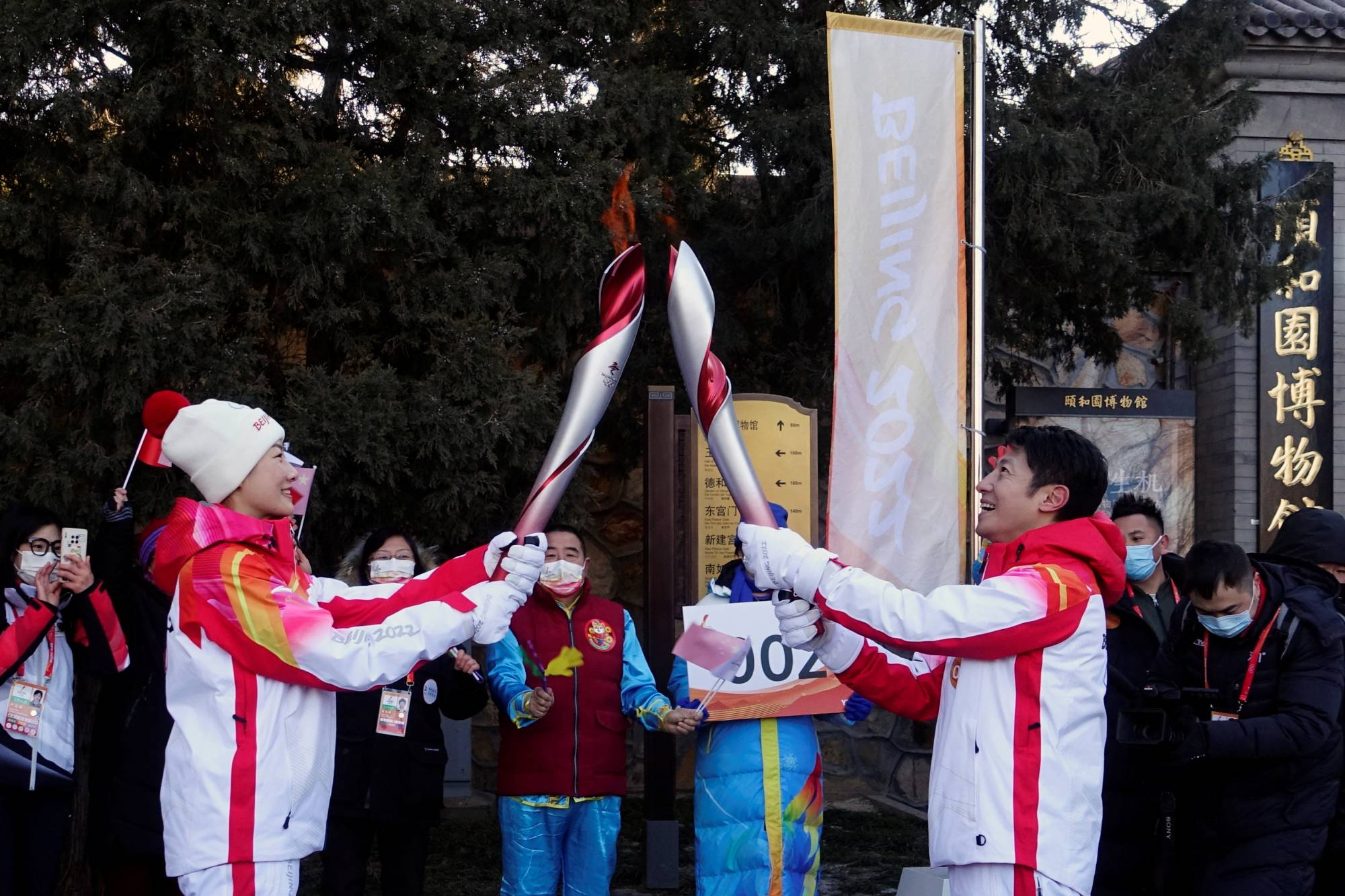 Torchbearers Ding Ning, Chinese table tennis player, and Sa Beining, Chinese state television host, relay the Olympic flame at the Summer Palace in the Haidian district of Beijing on Friday. | Reuters